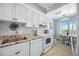 Bright kitchen with white cabinets, granite counters, matching appliances and adjacent breakfast nook at 1650 1St W Ave # 503B, Bradenton, FL 34205