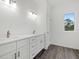 Bathroom with double vanity featuring white cabinets, quartz countertops, and bronze fixtures at Lot 20 Garafola Ave, North Port, FL 34291