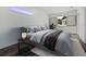 Serene bedroom featuring a gray upholstered bed, neutral decor, and ample natural light from the window at Lot 20 Garafola Ave, North Port, FL 34291