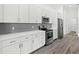 Modern kitchen featuring white cabinetry, stainless steel appliances, and a gray subway tile backsplash at Lot 20 Garafola Ave, North Port, FL 34291