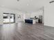 Open-concept living room with wood-look tile flooring and a kitchen island with a dark blue base at Lot 20 Garafola Ave, North Port, FL 34291