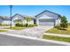 Two-car garage exterior featuring manicured landscaping and a brick paved driveway at 10519 Spring Tide Way, Parrish, FL 34219