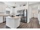Modern kitchen with stainless steel appliances, center island, and bright, white cabinets at 10519 Spring Tide Way, Parrish, FL 34219