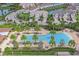An aerial view showcases a resort-style pool, lush landscaping, and nearby residences in the community at 11828 Sky Acres Ter, Bradenton, FL 34211