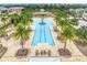 Aerial shot of a large community pool featuring a zero entry, lounge chairs, and palm trees at 11828 Sky Acres Ter, Bradenton, FL 34211