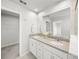 Bright bathroom with dual sinks, stone countertops, framed mirror, and walk-in shower at 11828 Sky Acres Ter, Bradenton, FL 34211