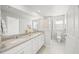 Bright bathroom with dual sinks, stone countertops, framed mirror, and walk-in shower at 11828 Sky Acres Ter, Bradenton, FL 34211