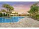 Beautiful community pool with palm trees and a sunset view, perfect for relaxation and recreation at 11828 Sky Acres Ter, Bradenton, FL 34211