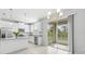Bright, open kitchen featuring white cabinets, stainless steel appliances, and a sliding glass door to the patio at 11828 Sky Acres Ter, Bradenton, FL 34211