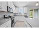Bright kitchen featuring stainless steel appliances, white cabinetry, and light countertops at 11828 Sky Acres Ter, Bradenton, FL 34211