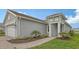 Gray home exterior featuring manicured landscaping, blue door, and tile roof at 12520 Brookgreen St, Venice, FL 34293