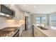 Beautiful kitchen featuring white cabinets, tile backsplash, and stainless steel appliances and island at 12520 Brookgreen St, Venice, FL 34293