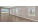 Bright living room featuring wood-look tile flooring, neutral walls, and backyard views at 12520 Brookgreen St, Venice, FL 34293