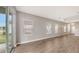 Open concept living room with wood-look tile floors, bright light, and large windows for natural light at 12520 Brookgreen St, Venice, FL 34293