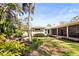 Well-maintained backyard with lush greenery, tropical plants, and a view of the home's exterior at 1538 S Orange Ave, Sarasota, FL 34239