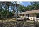 Backyard view of wooden patio with mature landscaping, perimeter fence and beige house at 1711 30Th W St, Bradenton, FL 34205
