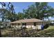 View of the fenced backyard with patio, mature landscaping and lawn at 1711 30Th W St, Bradenton, FL 34205