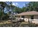Backyard view of wooden patio with mature landscaping, perimeter fence, and house at 1711 30Th W St, Bradenton, FL 34205