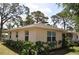 Exterior shot of the rear of the beige home with trimmed landscaping and perimeter fence at 1711 30Th W St, Bradenton, FL 34205