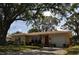 Welcoming one-story home with a manicured lawn, mature trees, and an inviting entrance at 1711 30Th W St, Bradenton, FL 34205