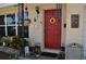 Inviting front porch adorned with hanging plants and a vibrant red front door with a decorative sunflower at 1711 30Th W St, Bradenton, FL 34205