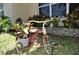 Unique front yard decor with a vintage tricycle planter, adding character and charm to the home's exterior at 1711 30Th W St, Bradenton, FL 34205