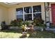 Charming front yard detail with an antique tricycle used as a planter, set against a backdrop of lush greenery at 1711 30Th W St, Bradenton, FL 34205