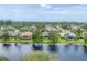 Aerial view of homes surrounding a pond, each featuring a screened-in lanai and lush landscaping at 1727 88Th Nw Ct, Bradenton, FL 34209