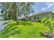 Beautiful backyard featuring a green lawn, waterfront view and a screened-in lanai, perfect for outdoor entertaining at 1727 88Th Nw Ct, Bradenton, FL 34209