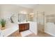 Stylish bathroom featuring a tiled glass shower, soaking tub with stone detail, and wood cabinet vanity at 1727 88Th Nw Ct, Bradenton, FL 34209