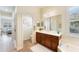 Bathroom showcasing a soaking tub, dark wood cabinets, hardwood floors and a large mirror reflecting ample natural light at 1727 88Th Nw Ct, Bradenton, FL 34209