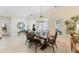Bright dining room with a wooden table set for six, complemented by a modern chandelier and elegant decor at 1727 88Th Nw Ct, Bradenton, FL 34209