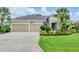 Inviting home with a well-kept lawn, two-car garage, and vibrant landscaping at 1727 88Th Nw Ct, Bradenton, FL 34209