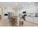 Bright kitchen features granite countertops, stainless steel appliances, white cabinetry, and bar seating for modern living at 1727 88Th Nw Ct, Bradenton, FL 34209