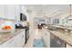 Spacious kitchen with granite countertops, stainless appliances, and bar seating seamlessly connecting to the living area at 1727 88Th Nw Ct, Bradenton, FL 34209