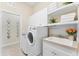 Bright laundry room with sink, cabinets, and decorative shelving, enhancing functionality and style at 1727 88Th Nw Ct, Bradenton, FL 34209