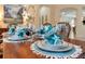 Elegant table setting features silver chargers, turquoise accents, and starfish decor for a coastal-chic dining experience at 1727 88Th Nw Ct, Bradenton, FL 34209