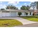 Charming single-story home featuring a well-manicured lawn, stone driveway, and attached garage with white picket fence at 2070 Carpetgreen St, Port Charlotte, FL 33948