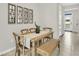 Cozy dining area with wood table and chairs, a woven bench, decor mirrors, and tile flooring at 2469 Mellow Ln, Clearwater, FL 33765