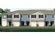 Charming townhome exterior showcasing a blue and grey facade, a one car garage, and beautifully landscaped front yard at 2469 Mellow Ln, Clearwater, FL 33765