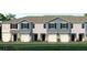 Charming townhome exterior showcasing a blue and grey facade, a one car garage, and beautifully landscaped front yard at 2469 Mellow Ln, Clearwater, FL 33765