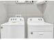 Functional laundry room with a new white washer and dryer, plus shelving for extra storage at 2477 Mellow Ln, Clearwater, FL 33765
