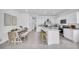 Spacious kitchen and dining area with white cabinets, marble countertops, and stainless steel appliances at 2481 Mellow Ln, Clearwater, FL 33765