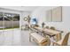 Bright open-concept living area with modern furnishings, dining space, and a sliding glass door at 2481 Mellow Ln, Clearwater, FL 33765