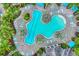 Aerial view of a resort-style pool with geometric shape, surrounded by ample seating and lush greenery at 27454 Hole In One Pl, Englewood, FL 34223