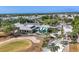 Stunning aerial view of the community clubhouse, golf course, and lush landscaping at 27454 Hole In One Pl, Englewood, FL 34223