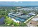 Aerial view of Boca Royale's tennis courts and clubhouse, surrounded by verdant landscaping at 27454 Hole In One Pl, Englewood, FL 34223