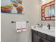 Charming powder room with decorative mirror, boat artwork, and modern sink at 27454 Hole In One Pl, Englewood, FL 34223