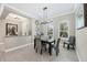 Bright dining room featuring modern chandelier, wainscoting, tile floors, and abundant natural light at 27454 Hole In One Pl, Englewood, FL 34223