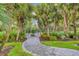 Landscaped entrance to a dog park with a paved walkway and plenty of trees and shrubs at 27454 Hole In One Pl, Englewood, FL 34223